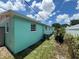 Side view of a light teal house with a small yard and AC unit at 5060 86Th Ave N, Pinellas Park, FL 33782