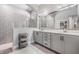 Bathroom featuring double vanity, large mirror and tiled shower with glass partition at 16701 Vibrato Ln, Land O Lakes, FL 34638
