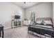 Cozy bedroom featuring carpet flooring, a black metal bed frame, and ample natural light at 16701 Vibrato Ln, Land O Lakes, FL 34638