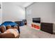 Bedroom with carpet floor, queen bed, drawers, baseball themed chair, and entertainment center at 16701 Vibrato Ln, Land O Lakes, FL 34638