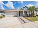 Charming single-Gathering home with a well-manicured lawn, stone accents, and a two-car garage at 16701 Vibrato Ln, Land O Lakes, FL 34638