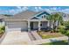 Beautiful single-story home with a well-kept lawn, stone accents, and a two-car garage at 16701 Vibrato Ln, Land O Lakes, FL 34638