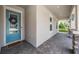 Inviting front porch featuring stone detailing, a blue door with wreath, and decorative brick flooring at 16701 Vibrato Ln, Land O Lakes, FL 34638