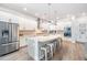 Modern kitchen featuring white cabinets, a large island with seating, and stainless steel appliances at 16701 Vibrato Ln, Land O Lakes, FL 34638