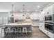Modern kitchen featuring white cabinets, a large island with seating, and stainless steel appliances at 16701 Vibrato Ln, Land O Lakes, FL 34638