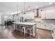 Open concept kitchen with a large island and seating, plus dining area with modern light fixture at 16701 Vibrato Ln, Land O Lakes, FL 34638