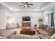 Open-concept living room featuring neutral decor, a ceiling fan, and ample seating for entertaining guests at 16701 Vibrato Ln, Land O Lakes, FL 34638