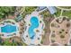Aerial view of two community pools, with one shaped like a clover, alongside a playground at 16701 Vibrato Ln, Land O Lakes, FL 34638