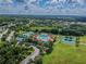 Aerial view of community pool, tennis courts and clubhouse surrounded by lush greenery at 19830 Ellendale Dr, Land O Lakes, FL 34638