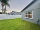 Spacious backyard with lush green grass, white fence and palm trees, offering privacy at 19830 Ellendale Dr, Land O Lakes, FL 34638