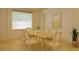 Bright dining room featuring light wood table, six chairs, neutral rug and large window at 19830 Ellendale Dr, Land O Lakes, FL 34638