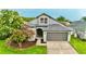 Charming single-Gathering home with lush landscaping, a well-maintained lawn, and an attached two-car garage at 19830 Ellendale Dr, Land O Lakes, FL 34638