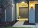 Inviting front entrance with double doors, manicured landscaping, and exterior lighting at 19830 Ellendale Dr, Land O Lakes, FL 34638