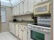 Full view of kitchen with white cabinets and granite countertops at 2060 Marilyn St # 124, Clearwater, FL 33765