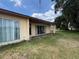 Back patio with sliding glass doors and grassy yard at 3754 Lake Joyce Dr, Land O Lakes, FL 34639