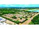 Wide aerial perspective of the community featuring charming townhomes, natural ponds, and green landscaping at 10254 Red Currant Ct, Riverview, FL 33578