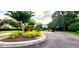 Beautifully landscaped community entrance featuring mature trees and colorful plantings, enhancing the neighborhood's appeal at 10254 Red Currant Ct, Riverview, FL 33578