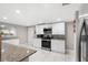 Updated kitchen boasts white cabinets, granite countertops, and stainless steel appliances at 1006 E Fern St, Tampa, FL 33604