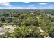 Aerial view showing home nestled in a lush, tree-lined neighborhood with city skyline in the distance at 1006 E Fern St, Tampa, FL 33604