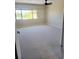 Spacious carpeted bedroom with large window and ceiling fan at 318 Windrush Blvd # 9, Indian Rocks Beach, FL 33785