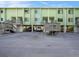Front view of a light green two-story building with parking underneath at 318 Windrush Blvd # 9, Indian Rocks Beach, FL 33785