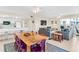 Open concept dining area with large wooden table and purple chairs at 19610 Gulf Blvd # 409, Indian Shores, FL 33785