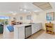 Open kitchen with stainless steel dishwasher and view into living room at 19610 Gulf Blvd # 409, Indian Shores, FL 33785