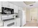 Kitchen with white cabinets, electric stove and microwave at 19610 Gulf Blvd # 409, Indian Shores, FL 33785