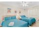 Bedroom with two double beds, ceiling fan, and beach-themed art at 19610 Gulf Blvd # 409, Indian Shores, FL 33785