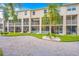 View of condo showing screened in porches and yard featuring palm trees, shrubs, and grass at 1109 Pinellas Bayway S # 306, Tierra Verde, FL 33715