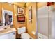 Bathroom with toilet, vanity, framed prints, towel rack and step-in shower at 1109 Pinellas Bayway S # 306, Tierra Verde, FL 33715