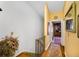 A bright hallway is accented by a decorative runner and opens to a room filled with a bookshelf and hardwood floors at 1109 Pinellas Bayway S # 306, Tierra Verde, FL 33715