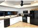 Bright kitchen with modern black appliances, white cabinetry, and convenient access to the sink area at 1109 Pinellas Bayway S # 306, Tierra Verde, FL 33715