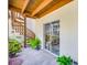 Enclosed patio with a spiral staircase, sliding glass door, and potted plants at 1109 Pinellas Bayway S # 306, Tierra Verde, FL 33715