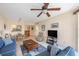 Bright living room features a ceiling fan and comfy seating at 8001 Sailboat Key S Blvd # 204, St Pete Beach, FL 33707