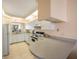 Condo kitchen with white cabinets and tile floor at 8001 Sailboat Key S Blvd # 204, St Pete Beach, FL 33707