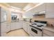 Condo kitchen with white appliances and water view at 8001 Sailboat Key S Blvd # 204, St Pete Beach, FL 33707