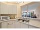 Kitchen with microwave, sink and living room view at 8001 Sailboat Key S Blvd # 204, St Pete Beach, FL 33707