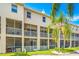 Condo building exterior with screened-in patios and lush landscaping at 1109 Pinellas Bayway S # 306, Tierra Verde, FL 33715