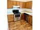Kitchen with wood cabinets, stainless steel appliances and wood-look floors at 5816 Congress St # 104, New Port Richey, FL 34653