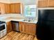 Kitchen with wood cabinets, stainless steel appliances and wood-look floors at 5816 Congress St # 104, New Port Richey, FL 34653