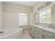 Bright bathroom features a soaking tub with subway tile surround and a double sink vanity with modern fixtures at 49 W Boyer St, Tarpon Springs, FL 34689