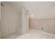 Clean bathroom features a tiled walk-in shower with seating with a modern shower head and white tiled floor at 49 W Boyer St, Tarpon Springs, FL 34689