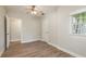 Light-filled bedroom with ceiling fan features wood-look floors and neutral walls with natural light from a window at 49 W Boyer St, Tarpon Springs, FL 34689