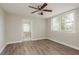 Light-filled bedroom with a ceiling fan, wood-look flooring, and access to bathroom at 49 W Boyer St, Tarpon Springs, FL 34689