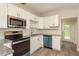 Updated kitchen features white cabinets, stainless steel appliances, and subway tile backsplash at 49 W Boyer St, Tarpon Springs, FL 34689