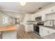 Open-concept kitchen featuring white cabinetry, granite countertops, and stainless-steel appliances at 49 W Boyer St, Tarpon Springs, FL 34689