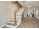 Open-concept living space featuring a staircase, wood-look floors, and access to the kitchen at 49 W Boyer St, Tarpon Springs, FL 34689