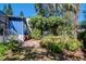 Landscaped backyard with tropical plants and a blue house at 1550 Chestnut W Ct, Palm Harbor, FL 34683