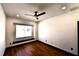 Bedroom with hardwood floors, fan, and a window with a seating area overlooking the yard at 1570 Preserve Way, Clearwater, FL 33764